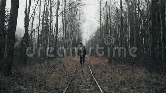 穿着军服在空寂的森林里走老铁路的流浪者视频的预览图