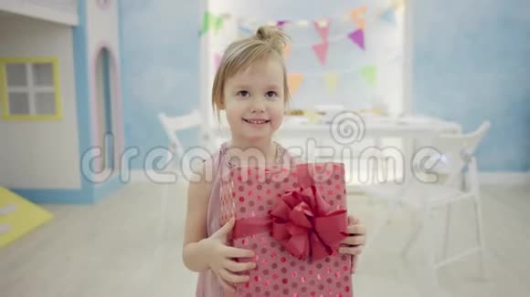 小女孩在镜头前摆着生日礼物视频的预览图
