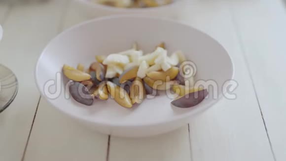 手持摄像机特写切好的水果在粉红色的Bouls水果沙拉健康早餐白色的顶部侧面视图视频的预览图