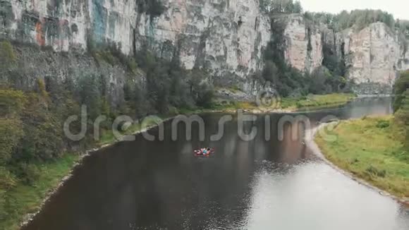 飞过河流河上漂浮着双体船漂流在一条带岩石的山河上视频的预览图