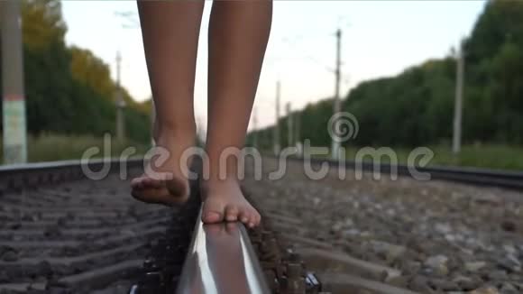 女孩赤脚走在铁路铁路上视频的预览图