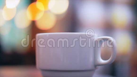 瓷杯咖啡屋灯光背景上有热咖啡视频的预览图