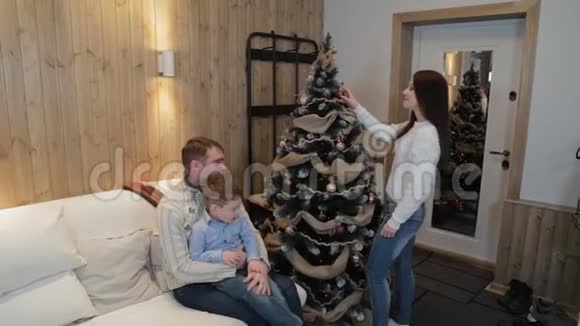 幸福的家庭装饰圣诞树在现代的室内视频的预览图