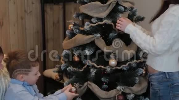 幸福的家庭装饰圣诞树在现代的室内视频的预览图