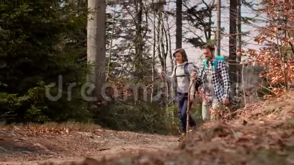 带着背包在森林里徒步旅行的爸爸和儿子微笑视频的预览图