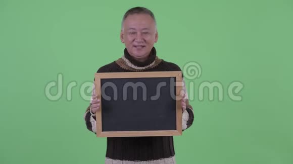 快乐成熟的日本男人拿着黑板说话视频的预览图