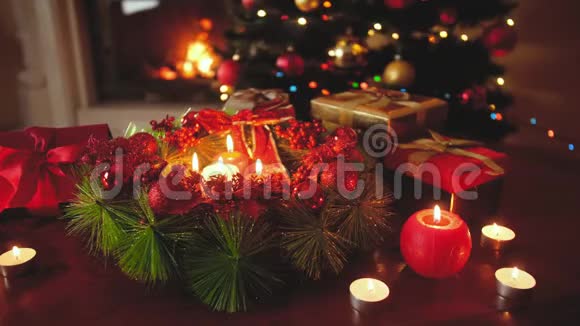 4k镜头美丽装饰的礼物花环与燃烧的蜡烛在发光的圣诞树完美的背景视频的预览图