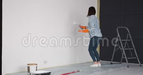 女人在欢乐的心情中画公寓墙视频的预览图