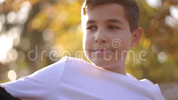 把穿白色毛衣的十几岁男孩关在长凳上带背包的帅哥学校男孩视频的预览图