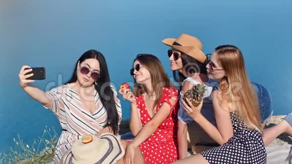 一群快乐的旅行女性在海上背景下用智能手机自拍拥有积极的情感视频的预览图