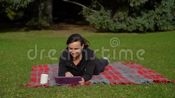 在公园里用平板电脑的女人视频的预览图