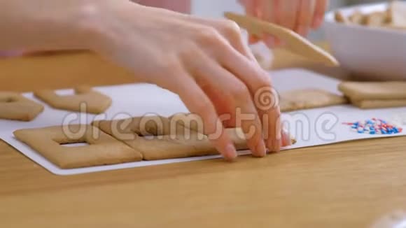女人在黑板上放姜饼屋的甜饼烹饪自制姜饼屋视频的预览图
