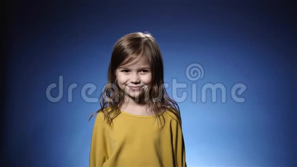 可爱的小女孩笑纸屑掉落饼干蓝色背景慢动作视频的预览图