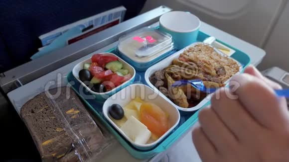 女人在飞机上吃饭飞行时食物放在托盘上手特写视频的预览图