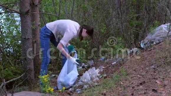 志愿者在公园湖边的森林里捡垃圾收集垃圾视频的预览图