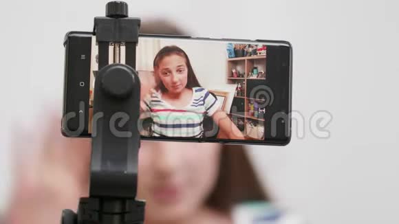 少女在智能手机上拍摄自己视频的预览图