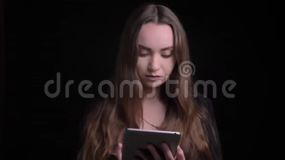 用平板电脑拍摄年轻漂亮的白人女性的特写镜头然后在背景隔离的情况下观看相机视频的预览图