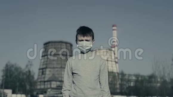 一个男孩戴着防止工厂烟囱冒出烟的污染面罩空气污染概念视频的预览图