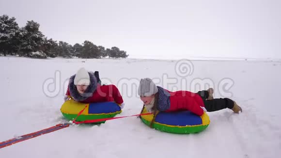 圣诞节期间一家人在冬季公园玩耍快乐的妈妈孩子们冬天在雪地里滑冰玩耍视频的预览图