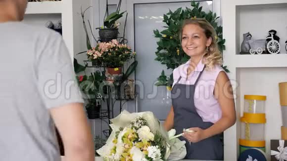 女花店售卖商在花店给男顾客送花束视频的预览图