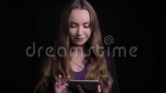 年轻迷人的黑发长毛白种人女性使用平板电脑特写镜头并显示绿色彩色屏幕视频的预览图