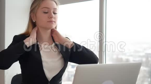 厌倦了做颈部按摩的经理在商业女性的笔记本电脑上努力工作视频的预览图