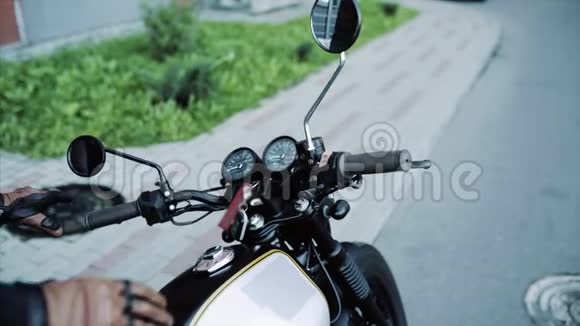 戴皮手套和黑色帽衫的自行车开始摩托车视频的预览图