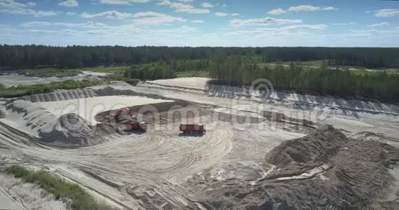 挖土机在沙坑空中装载矿石的自卸卡车视频的预览图