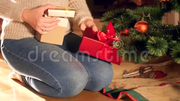4k视频年轻母亲把装有圣诞礼物的盒子放在圣诞树下视频的预览图