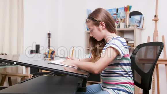 少女坐在书桌前用铅笔画东西视频的预览图