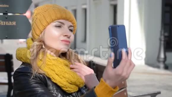 城市场景中迷人的女孩在手机上自拍视频的预览图