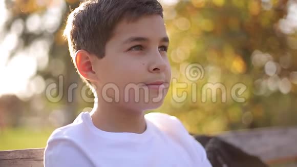 把穿白色毛衣的少年男孩关在长凳上带背包的帅哥学校男孩视频的预览图