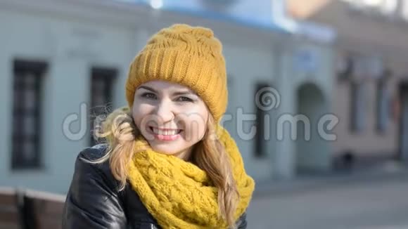 城市街道背景上一位迷人的年轻女子在镜头前微笑的肖像视频的预览图