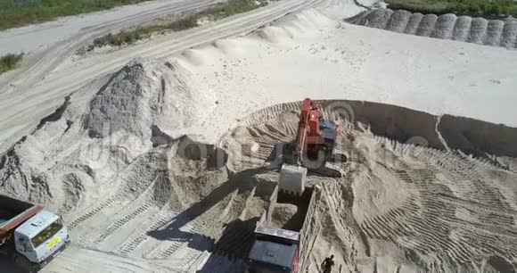 挖掘机于采砂场上景将矿石装入空铲运机视频的预览图