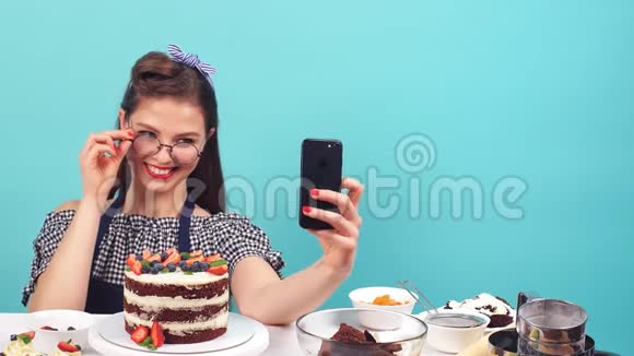 可爱的糕点女孩手里拿着纸杯蛋糕自拍视频的预览图