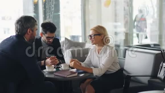 穿着正式服装的快乐同事在午休时在咖啡馆里微笑视频的预览图