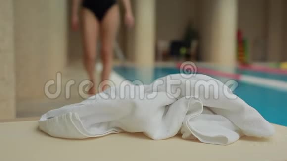 女人在泳池里用毛巾擦脚视频的预览图
