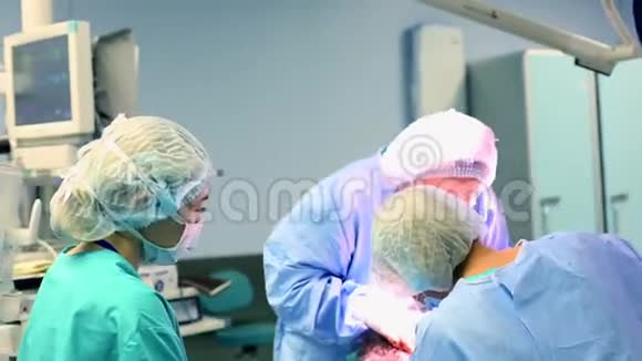一间现代化的手术室一组外科医生正在做手术外科医生和助手在现代的手术中工作视频的预览图