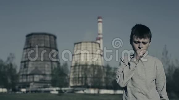 小男孩咳嗽把污染面罩放在工厂烟囱上空气污染概念视频的预览图