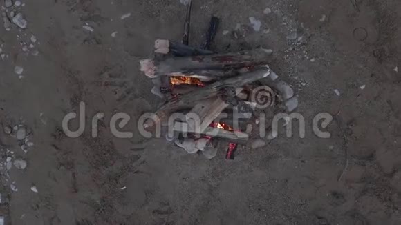 在河的沙岸上拍摄篝火顶部视图视频的预览图
