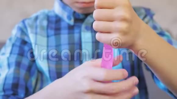 男孩的手伸出一个粉红色的黏液男孩玩黏液视频的预览图