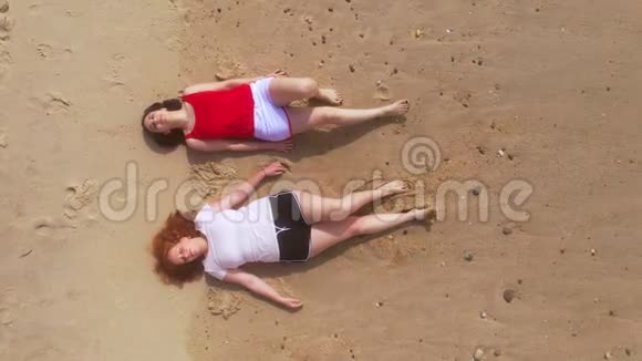在海滩上度过美好的一天两个女孩穿过沙滩视频的预览图