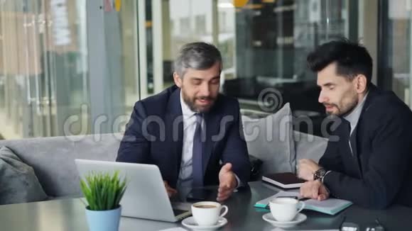 成熟的男性商业伙伴在咖啡馆里谈交易视频的预览图