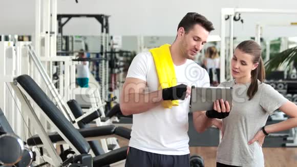 体育男性广告女性使用电脑平板电脑在健身房视频的预览图