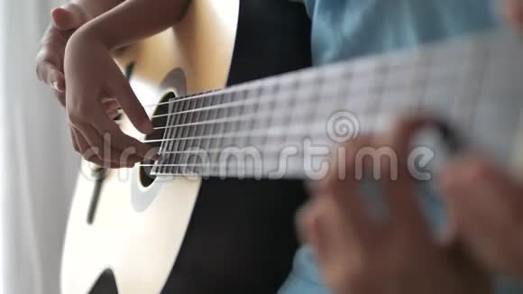 一位母亲近距离地教女儿如何演奏古典吉他家庭活动为自学c视频的预览图