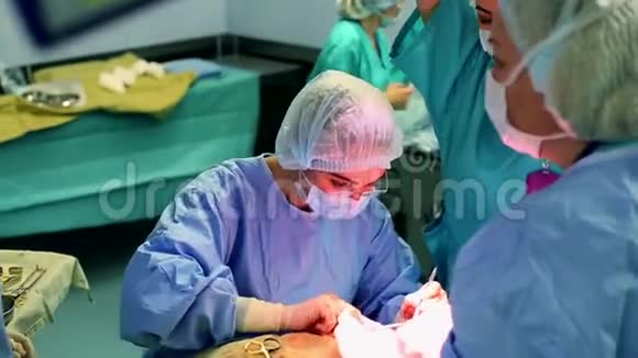 一间现代化的手术室一组外科医生正在做手术外科医生和助手在现代的手术中工作视频的预览图