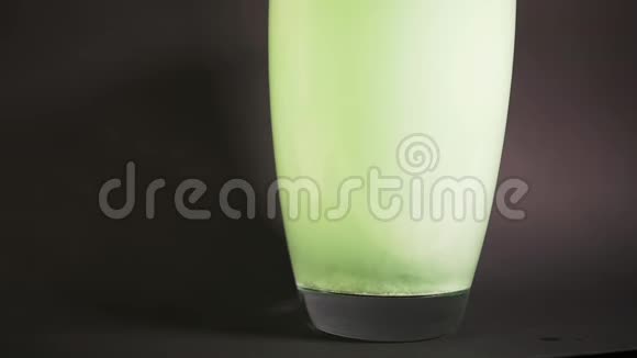 绿色浴盐缓慢地溶解在水的花瓶中用粒子钻视频的预览图