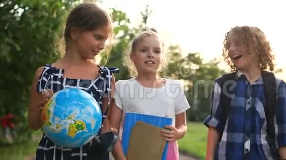 两个女孩和一个男孩晚上放学回来女孩手里拿着一个大地球仪一群青少年视频的预览图