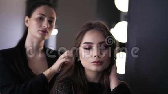 女化妆师一头乌黑的头发一位年轻的女士看着镜子欣赏着一份美容工作视频的预览图