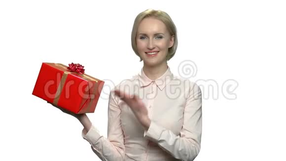 微笑的女人展示红色礼品盒视频的预览图
